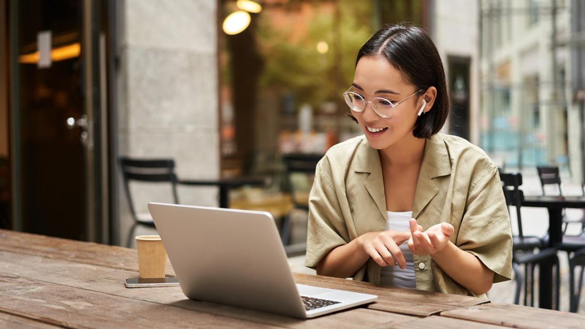 Person using a laptop and phone at a desk