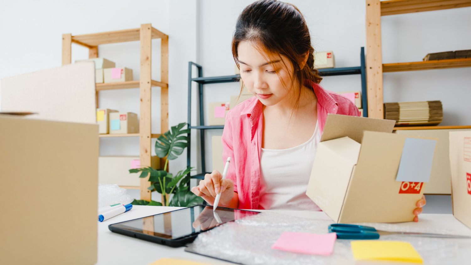 Online store owner managing orders and parcels on a tablet