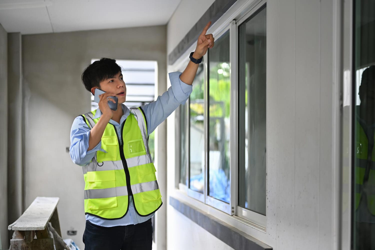 Site worker inspecting the upper edge of an installed window frame