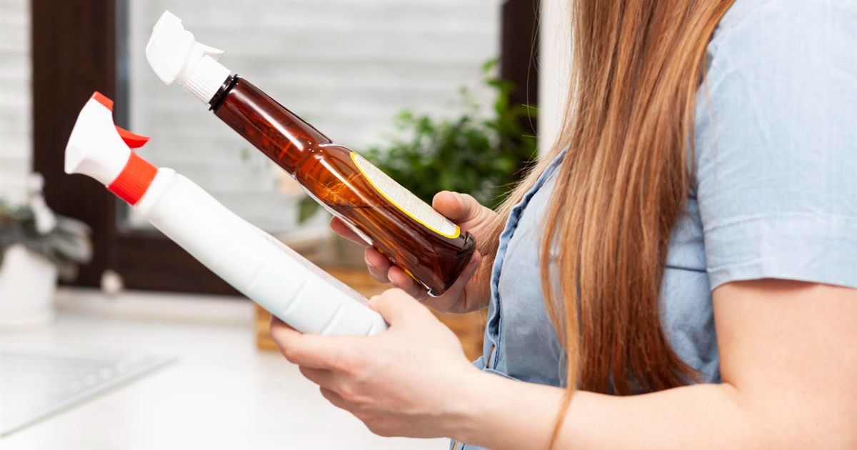 Person checking the labels on two cleaning product bottles